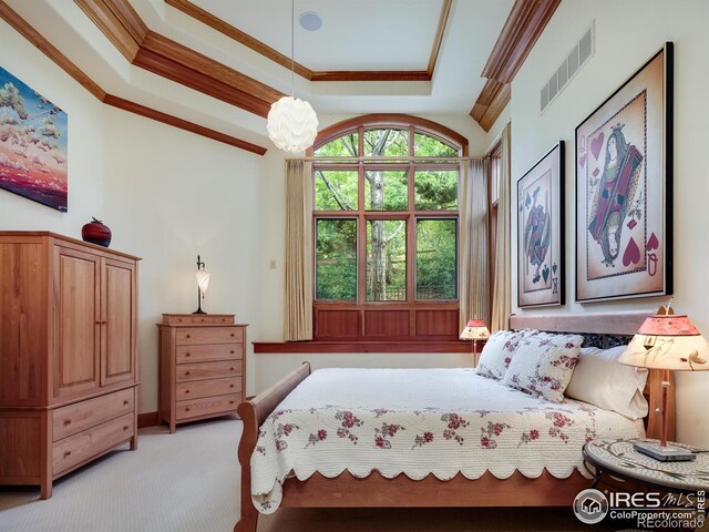 bedroom featuring light carpet, crown molding, and a tray ceiling