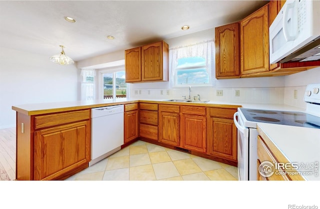 kitchen with sink, hanging light fixtures, backsplash, kitchen peninsula, and white appliances