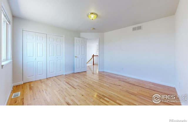 unfurnished bedroom featuring light hardwood / wood-style flooring and a closet