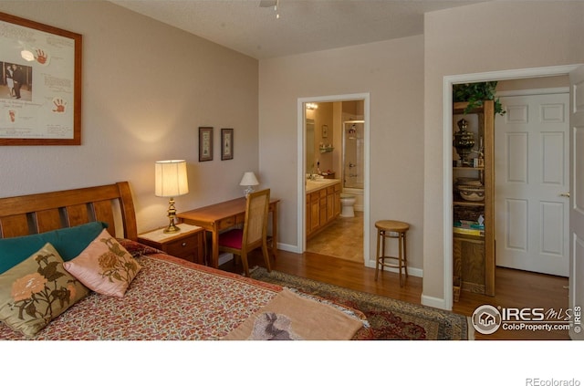 bedroom featuring connected bathroom and hardwood / wood-style flooring