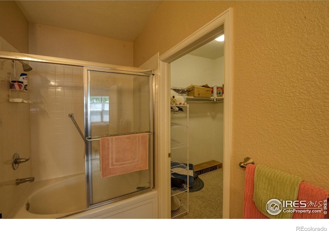 bathroom with bath / shower combo with glass door