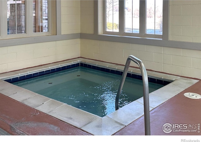 view of swimming pool featuring an indoor hot tub