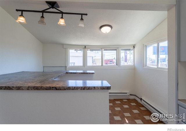 kitchen with a textured ceiling, track lighting, hanging light fixtures, and a baseboard radiator