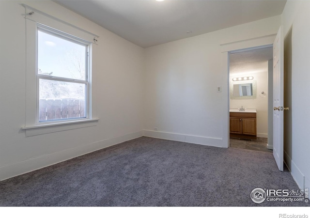 unfurnished room with sink and dark carpet