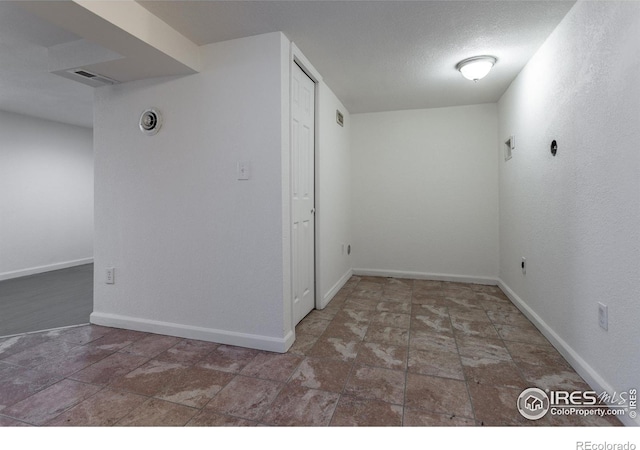 unfurnished room featuring a textured ceiling