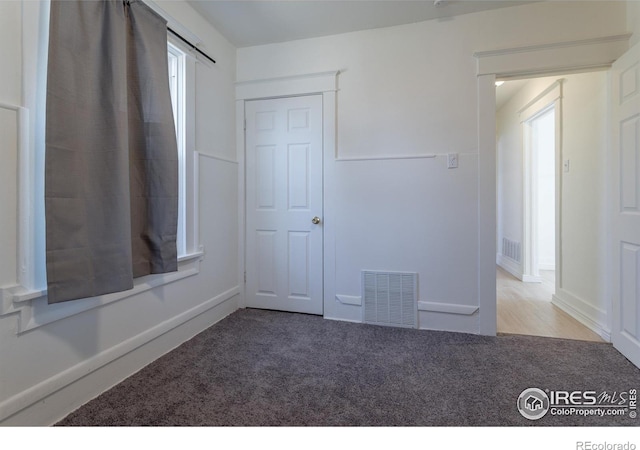 spare room featuring carpet flooring and a wealth of natural light