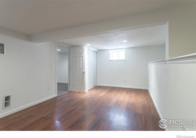 basement with dark hardwood / wood-style flooring