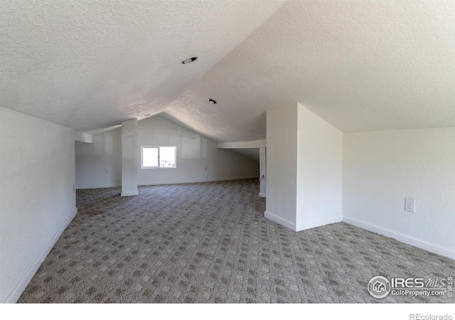 bonus room featuring a textured ceiling and vaulted ceiling