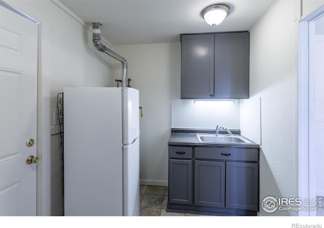 kitchen featuring gray cabinets, white refrigerator, and sink