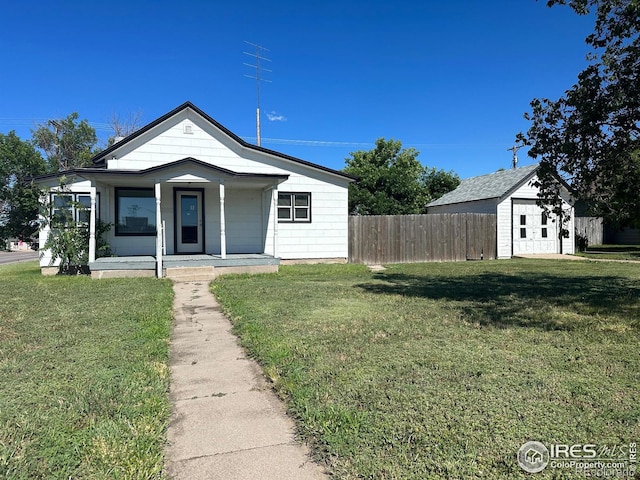 view of front of home with a shed, covered porch, and a front yard