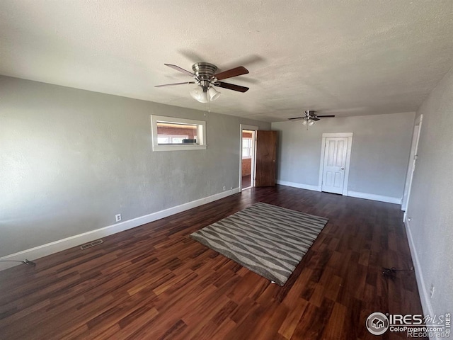 spare room with a textured ceiling, dark hardwood / wood-style floors, and ceiling fan