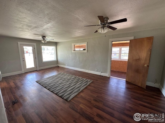 interior space featuring dark hardwood / wood-style flooring, ceiling fan, and a healthy amount of sunlight