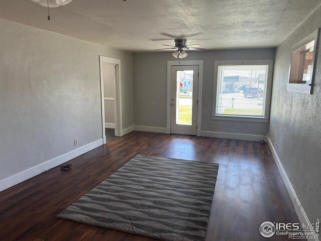 empty room with ceiling fan and dark hardwood / wood-style flooring