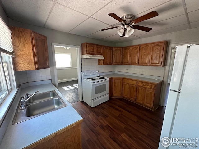 kitchen featuring a drop ceiling, white appliances, sink, and tasteful backsplash