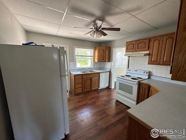 kitchen with a paneled ceiling, decorative backsplash, dark hardwood / wood-style floors, and white appliances