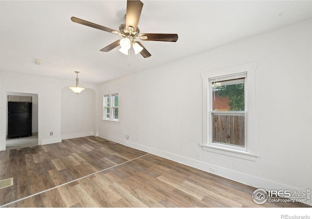 unfurnished living room featuring plenty of natural light, ceiling fan, and hardwood / wood-style flooring