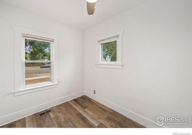 unfurnished room featuring dark wood-type flooring, ceiling fan, and a healthy amount of sunlight