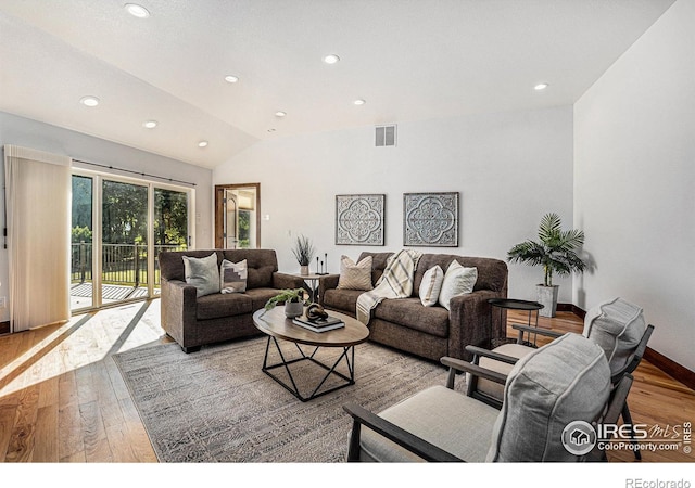 living room featuring lofted ceiling and light wood-type flooring