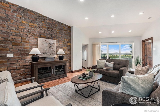 living room with light hardwood / wood-style flooring and lofted ceiling