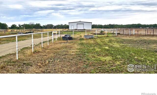 view of yard featuring a rural view and an outbuilding