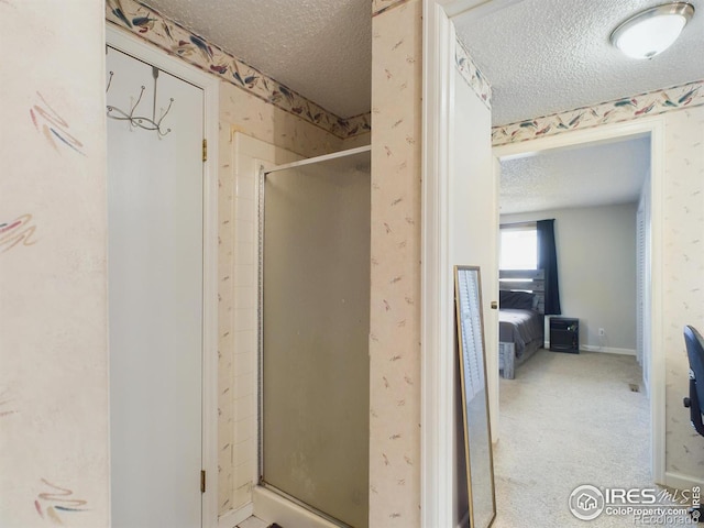 ensuite bathroom with a textured ceiling, ensuite bath, a shower stall, baseboards, and wallpapered walls