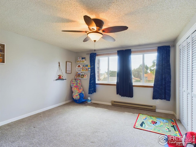 rec room with carpet, a baseboard heating unit, a ceiling fan, a textured ceiling, and baseboards