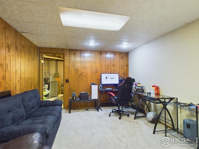 carpeted office space featuring wood walls