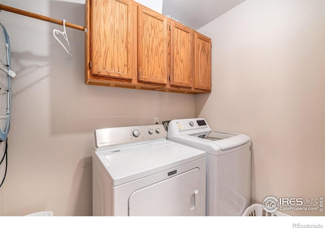 laundry area featuring independent washer and dryer and cabinets