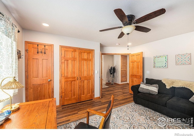 living room with dark wood-type flooring and ceiling fan