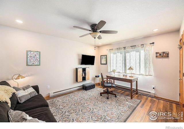 office area with hardwood / wood-style flooring, a baseboard radiator, ceiling fan, and a textured ceiling