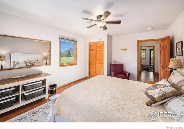 bedroom featuring dark wood-type flooring, ceiling fan, and a closet