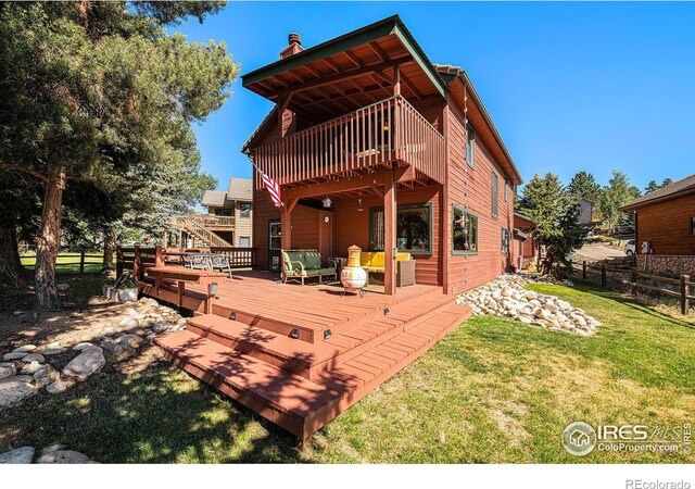 rear view of property with a wooden deck, a yard, and an outdoor living space