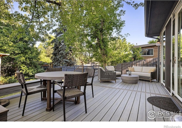 wooden terrace with an outdoor living space