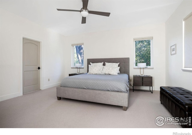 bedroom with light carpet, multiple windows, and ceiling fan