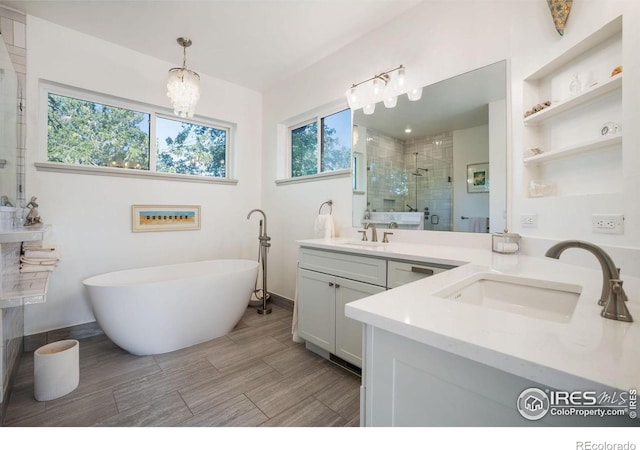 bathroom featuring vanity, independent shower and bath, and an inviting chandelier