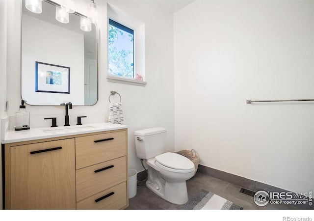 bathroom featuring tile patterned flooring, vanity, and toilet