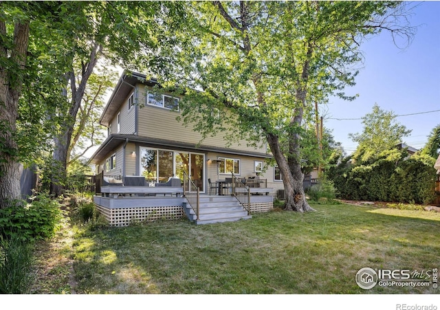 back of house featuring a yard and a wooden deck