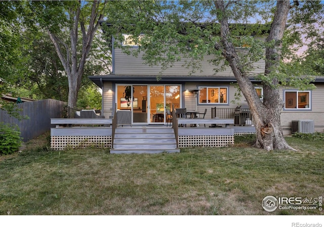 back of house featuring a lawn, central air condition unit, and a wooden deck