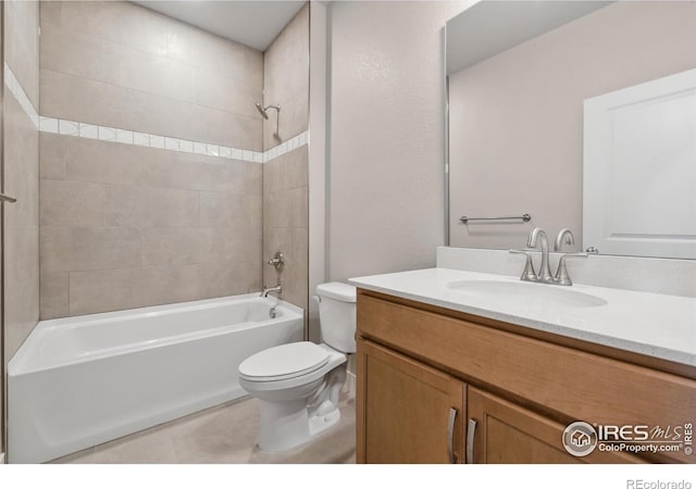 full bathroom with tile patterned flooring, toilet, tiled shower / bath, and vanity