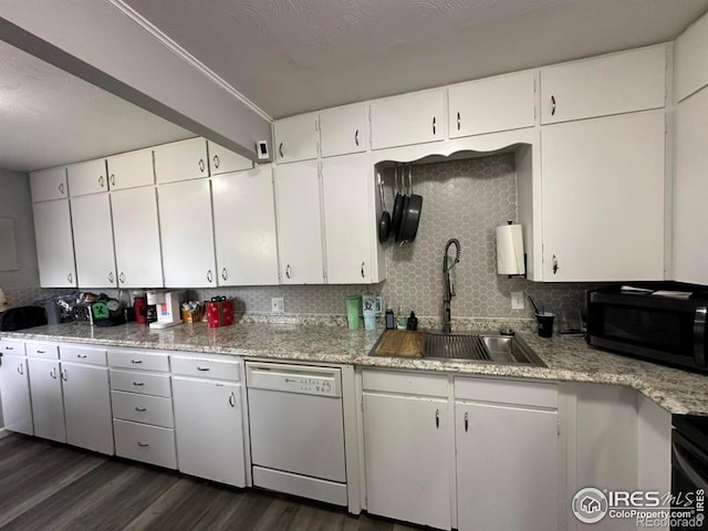 kitchen featuring tasteful backsplash, dark wood-type flooring, white dishwasher, black microwave, and a sink