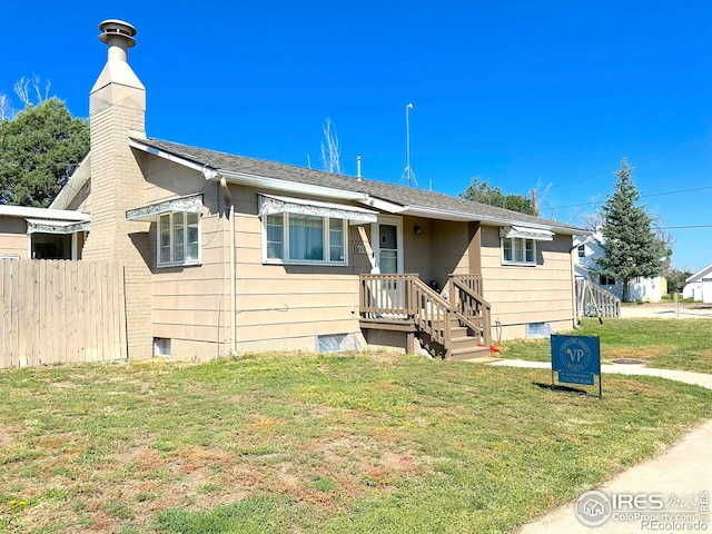 exterior space with a front yard, roof with shingles, fence, and a chimney