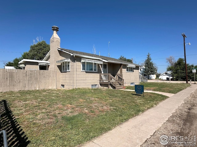 view of front of home with a front yard, fence, and a chimney