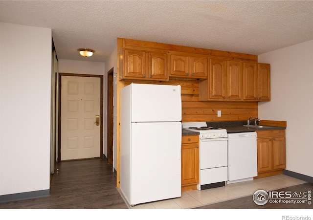 kitchen with white appliances, sink, and a textured ceiling