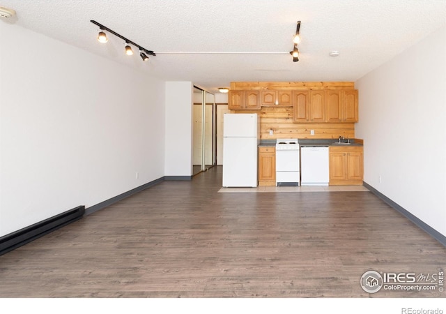 kitchen featuring sink, white appliances, dark wood-type flooring, rail lighting, and a textured ceiling