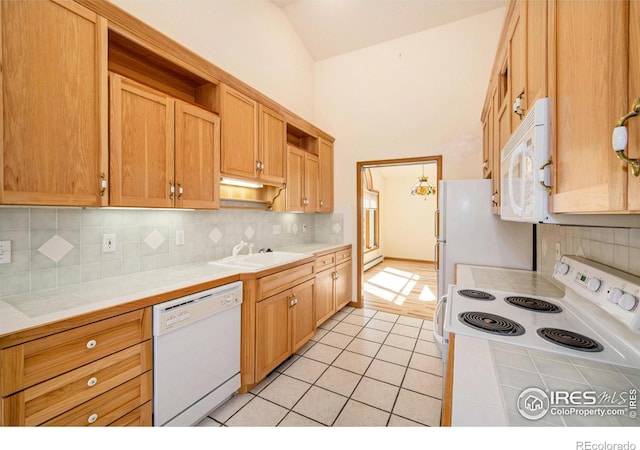 kitchen featuring white appliances, tile countertops, and tasteful backsplash