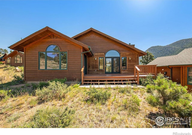 back of property featuring a deck with mountain view