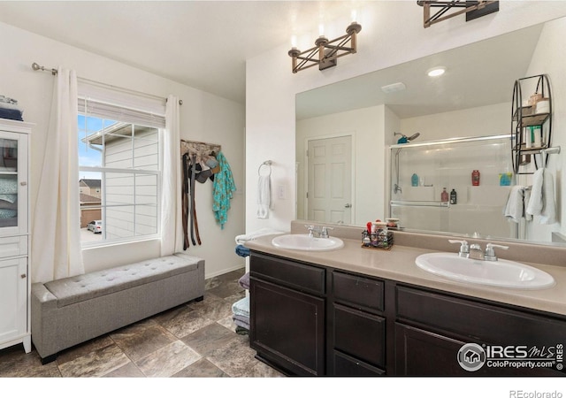 bathroom with a chandelier, vanity, and a shower with door