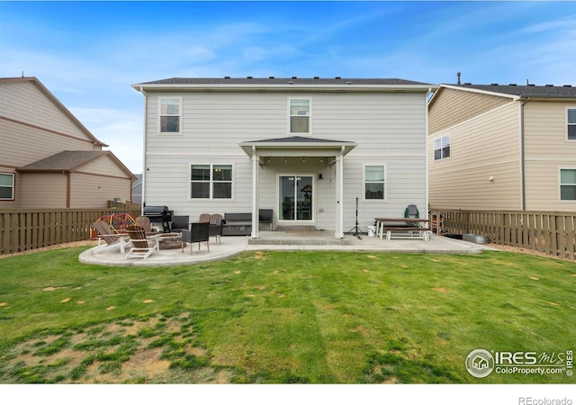 rear view of property featuring a lawn and a patio