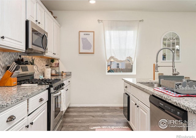 kitchen featuring light stone countertops, sink, white cabinets, and stainless steel appliances