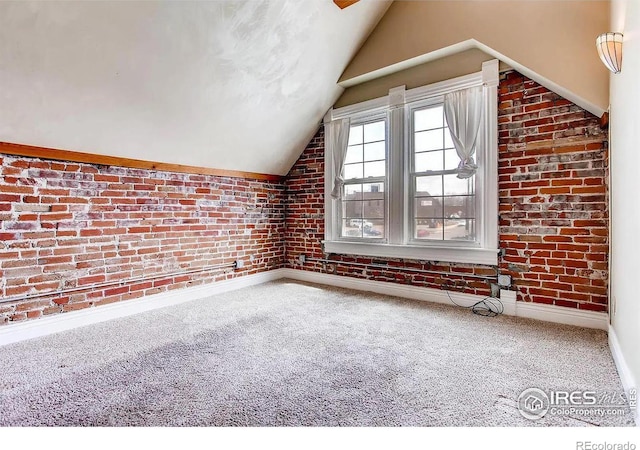 bonus room featuring carpet flooring, brick wall, and vaulted ceiling